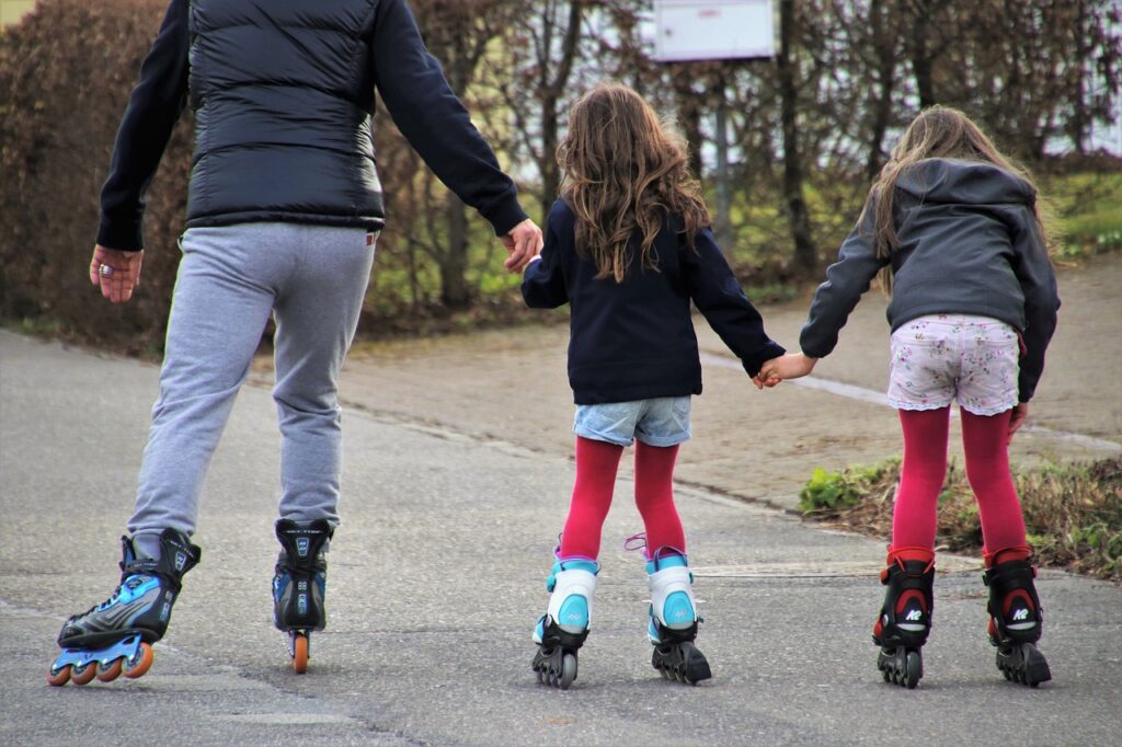 "Au Pair llevando a patinar a dos hermanas por el parque en USA"